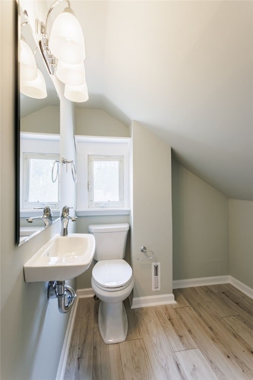 121 Barnard St, Greece, NY 14616 - bathroom with lofted ceiling, toilet, wood finished floors, plenty of natural light, and a sink