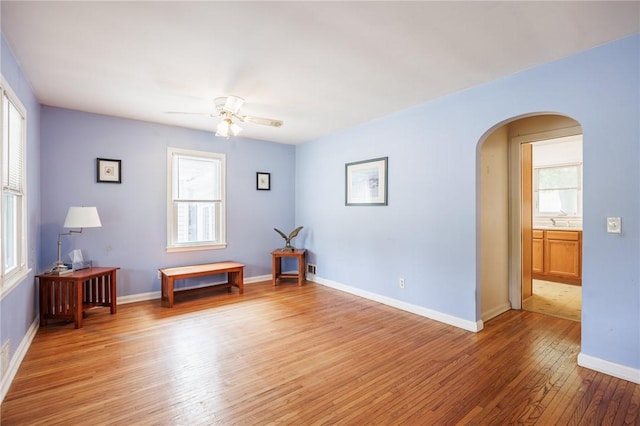 223 S Ave, Parma, NY 14468 - empty room with arched walkways, plenty of natural light, light wood-style floors, and a ceiling fan