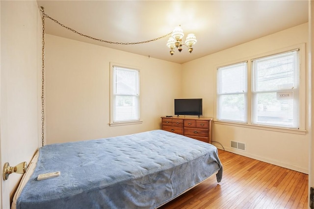 223 S Ave, Parma, NY 14468 - bedroom with hardwood / wood-style flooring, a chandelier, and baseboards