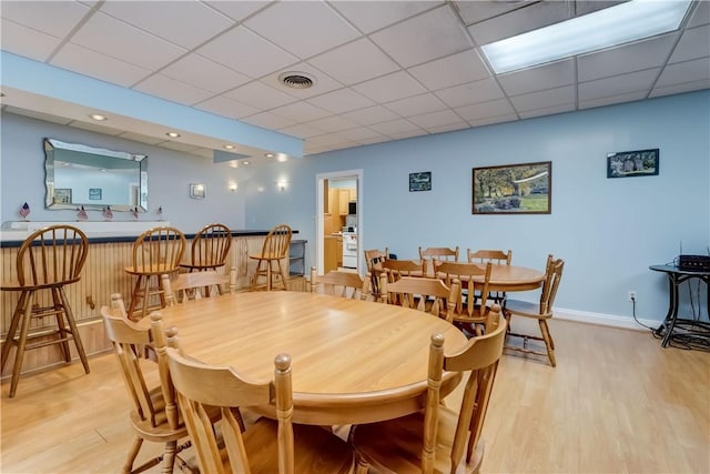 503 Valley Creek Rd, Gates, NY 14624 - dining room with light wood-style floors, bar, a paneled ceiling, and baseboards