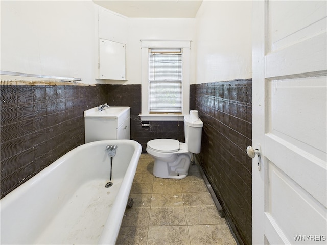 465 10th St, Niagara Falls, NY 14303 - full bath with tile walls, a tub to relax in, wainscoting, toilet, and vanity
