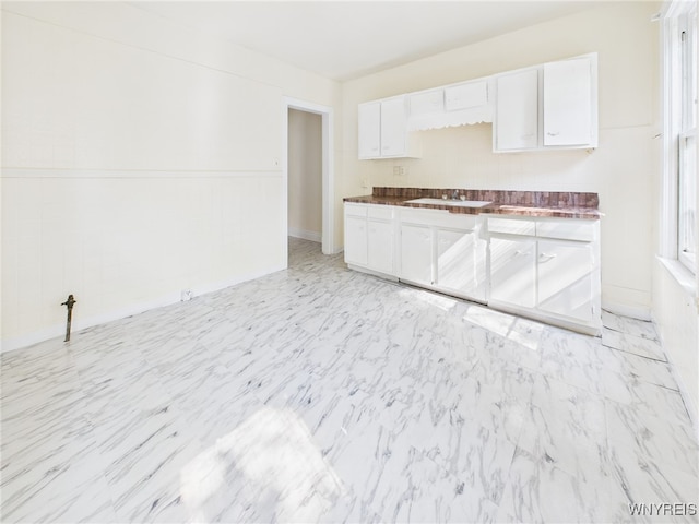 465 10th St, Niagara Falls, NY 14303 - kitchen featuring white cabinets, dark countertops, a sink, and light marble finish floors