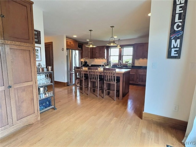 7294 Chase Rd, Pompey, NY 13063 - kitchen with freestanding refrigerator, a kitchen bar, light wood-style flooring, a center island, and baseboards