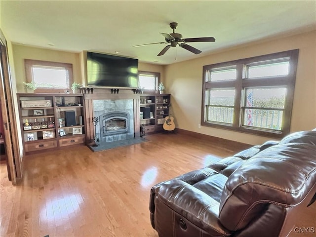 7294 Chase Rd, Pompey, NY 13063 - living area featuring wood finished floors, a tiled fireplace, ceiling fan, and baseboards
