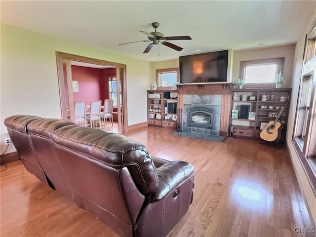 7294 Chase Rd, Pompey, NY 13063 - living room with wood finished floors, a tiled fireplace, ceiling fan, and baseboards