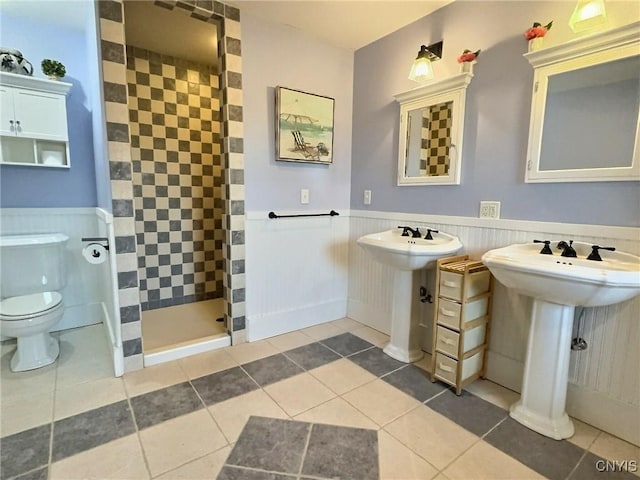 7294 Chase Rd, Pompey, NY 13063 - bathroom featuring tiled shower, toilet, a wainscoted wall, tile patterned flooring, and a sink