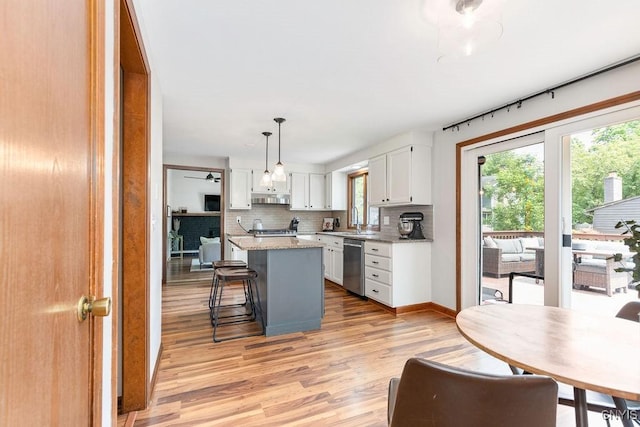 4292 Persimmon, Clay, NY 13090 - kitchen with dishwasher, light wood-style flooring, white cabinetry, a kitchen island, and tasteful backsplash