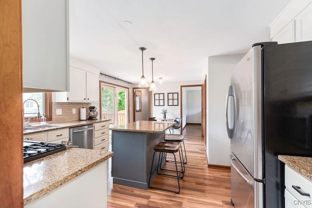 4292 Persimmon, Clay, NY 13090 - kitchen with stainless steel appliances, a sink, light wood-style floors, white cabinetry, and a center island