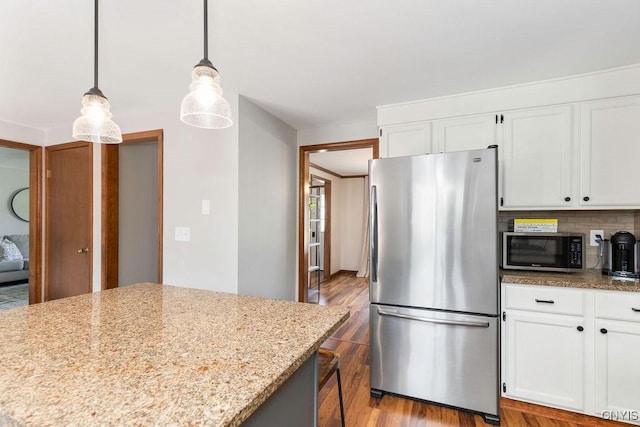4292 Persimmon, Clay, NY 13090 - kitchen featuring stainless steel appliances, wood finished floors, white cabinetry, light stone countertops, and decorative backsplash