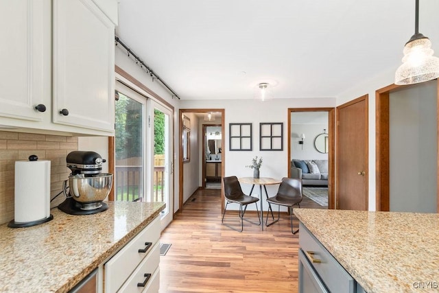 4292 Persimmon, Clay, NY 13090 - kitchen with light wood-style flooring, white cabinets, tasteful backsplash, pendant lighting, and light stone countertops