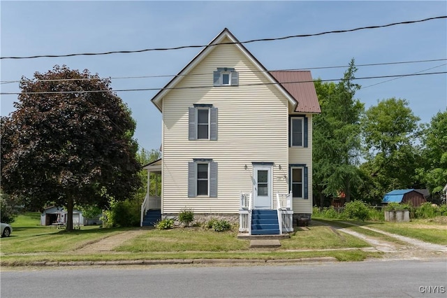 25 Waid St, Gouverneur, NY 13642 - traditional-style house featuring a front lawn and metal roof