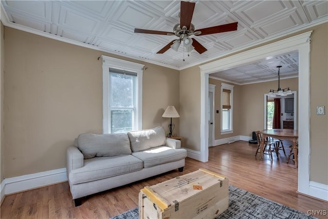 25 Waid St, Gouverneur, NY 13642 - living area featuring ceiling fan, baseboards, light wood-style flooring, a chandelier, and an ornate ceiling