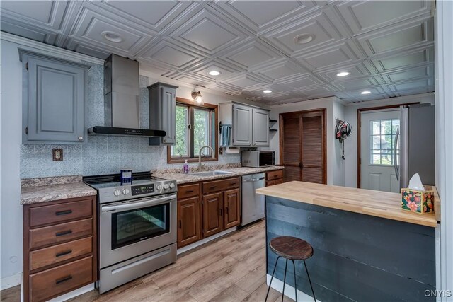 25 Waid St, Gouverneur, NY 13642 - kitchen featuring stainless steel appliances, a sink, an ornate ceiling, wall chimney exhaust hood, and light wood finished floors