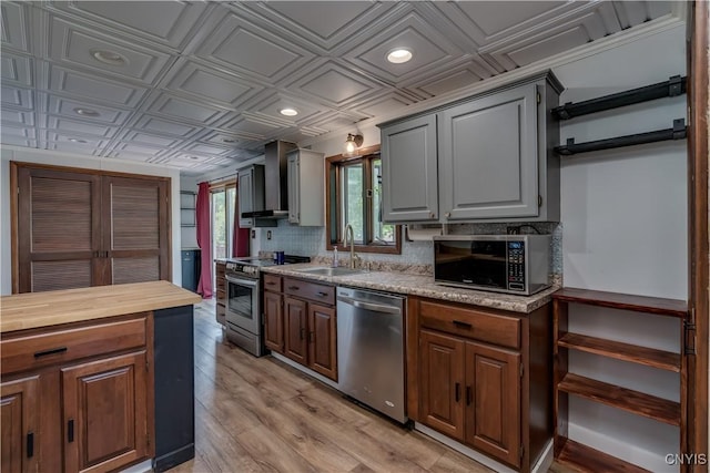 25 Waid St, Gouverneur, NY 13642 - kitchen with appliances with stainless steel finishes, an ornate ceiling, wall chimney exhaust hood, light wood-style flooring, and a sink