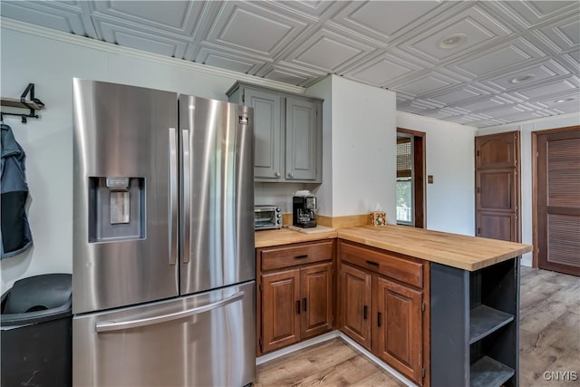 25 Waid St, Gouverneur, NY 13642 - kitchen featuring stainless steel fridge, an ornate ceiling, wood counters, open shelves, and a peninsula