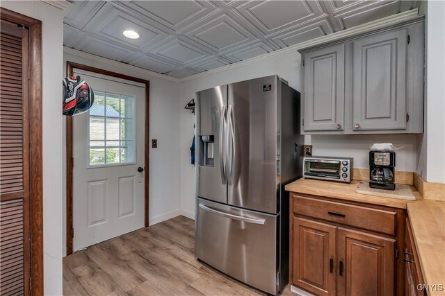 25 Waid St, Gouverneur, NY 13642 - kitchen with stainless steel refrigerator with ice dispenser, wooden counters, light wood-style flooring, an ornate ceiling, and baseboards
