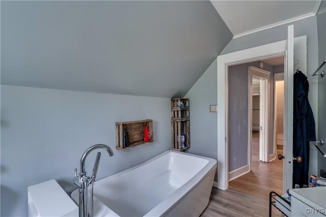 25 Waid St, Gouverneur, NY 13642 - full bath featuring vaulted ceiling, wood finished floors, a freestanding bath, and baseboards