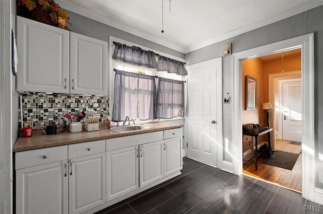817 Mildred Ave, Utica, NY 13502 - kitchen with white cabinets, a sink, decorative backsplash, ornamental molding, and dark wood-style floors