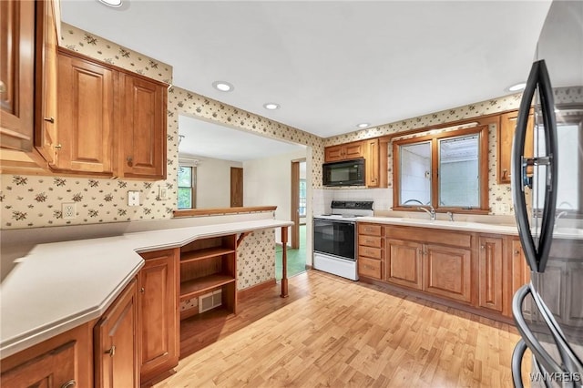 27 Lynn Lea St, Amherst, NY 14221 - kitchen featuring white electric range, freestanding refrigerator, black microwave, wallpapered walls, and light wood-style flooring