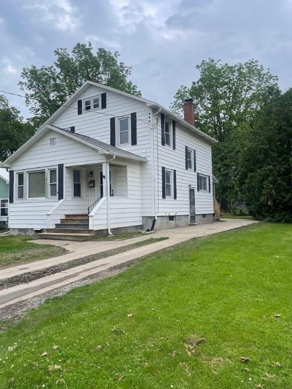 10 Hoffman St, Auburn, NY 13021 - view of front of house featuring a chimney, a front lawn, and covered porch