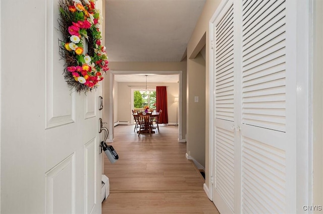 1 Christopher Cir, New Hartford, NY 13413 - hallway with baseboard heating, light wood-type flooring, baseboards, and a chandelier