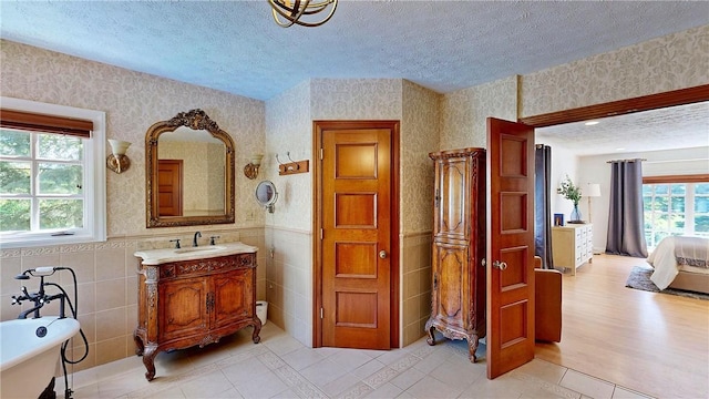11 Sunrise Park, Pittsford, NY 14534 - ensuite bathroom featuring a textured ceiling, a freestanding tub, wallpapered walls, tile patterned floors, and vanity
