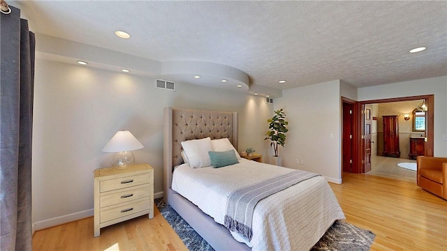 11 Sunrise Park, Pittsford, NY 14534 - bedroom with light wood-type flooring, recessed lighting, a textured ceiling, baseboards, and connected bathroom