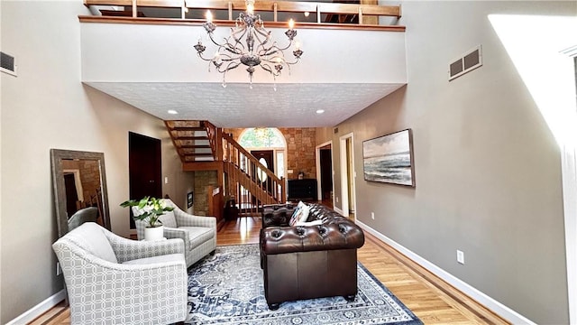 11 Sunrise Park, Pittsford, NY 14534 - living area with stairs, a chandelier, wood finished floors, baseboards, and a towering ceiling