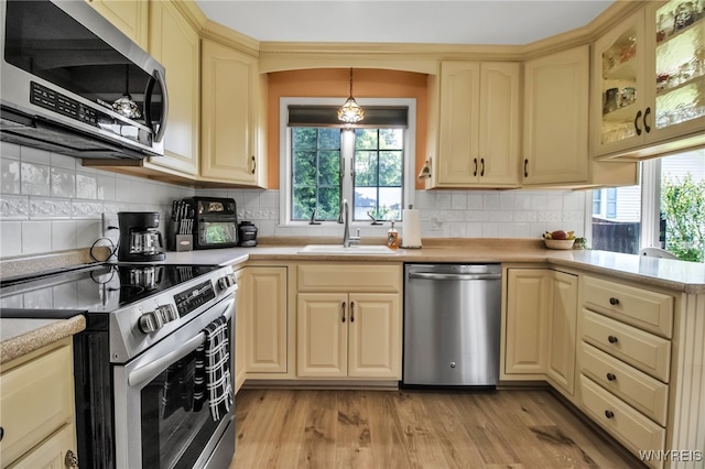 669 Quaker Rd, Aurora, NY 14052 - kitchen with stainless steel appliances, a sink, cream cabinets, light countertops, and healthy amount of natural light