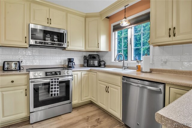 669 Quaker Rd, Aurora, NY 14052 - kitchen featuring appliances with stainless steel finishes, cream cabinets, a sink, light countertops, and decorative backsplash