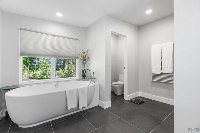 3 Elson Ln, Skaneateles, NY 13152 - bathroom featuring a freestanding tub, toilet, baseboards, tile patterned floors, and recessed lighting