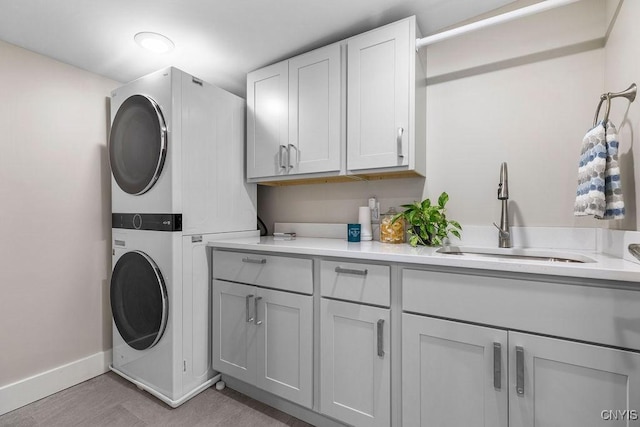 3 Elson Ln, Skaneateles, NY 13152 - laundry area featuring stacked washer / drying machine, cabinet space, and baseboards