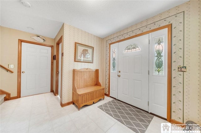 7080 Goodrich Rd, Clarence, NY 14032 - foyer featuring wallpapered walls, baseboards, and stairs