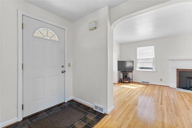 55 Heberton Rd, Irondequoit, NY 14622 - entrance foyer featuring arched walkways, baseboards, wood finished floors, and a fireplace