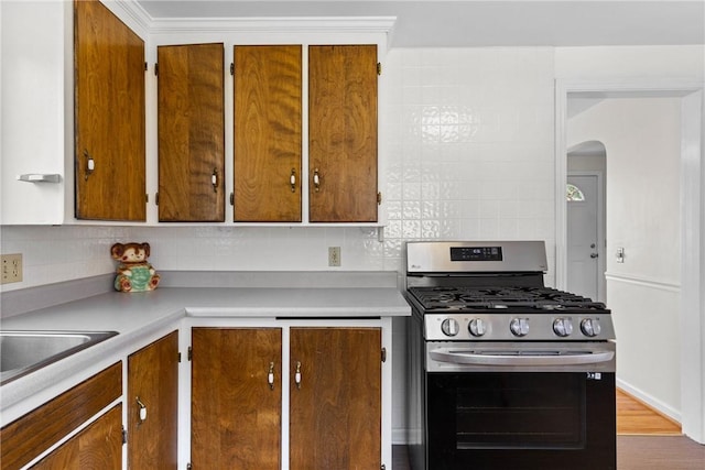 55 Heberton Rd, Irondequoit, NY 14622 - kitchen with gas range, light countertops, decorative backsplash, arched walkways, and brown cabinets