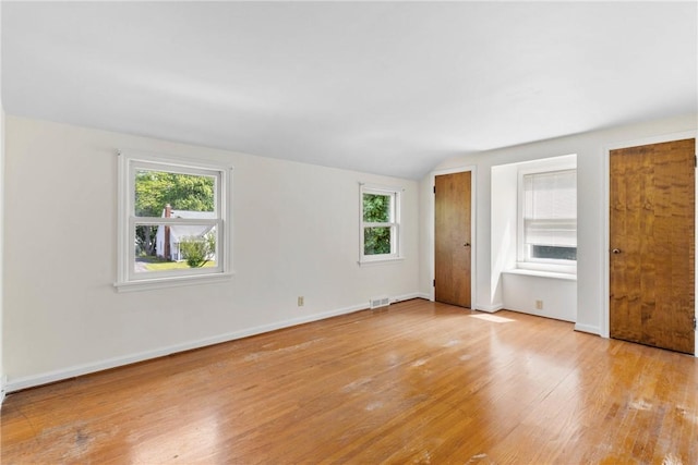 55 Heberton Rd, Irondequoit, NY 14622 - unfurnished bedroom with multiple closets, multiple windows, light wood-style floors, baseboards, and vaulted ceiling