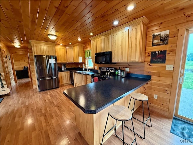 25003 State Route 37, Pamelia, NY 13601 - kitchen featuring black appliances, light brown cabinets, a sink, light wood finished floors, and a kitchen breakfast bar
