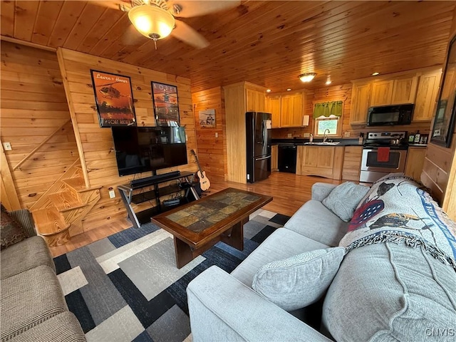 25003 State Route 37, Pamelia, NY 13601 - living room with light wood-style flooring, wood walls, wooden ceiling, and a ceiling fan