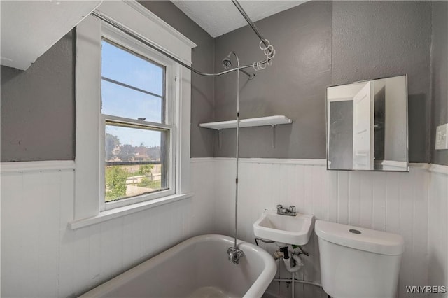 614 20th St, Niagara Falls, NY 14301 - full bathroom with a tub to relax in, a wainscoted wall, toilet, and a sink
