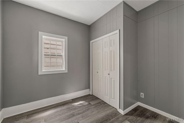 614 20th St, Niagara Falls, NY 14301 - unfurnished bedroom featuring dark wood-style floors, baseboards, a closet, and a textured ceiling