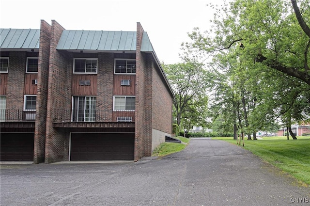 1215-29 James St, Syracuse, NY 13203 - view of home's exterior featuring a standing seam roof, an attached garage, brick siding, and metal roof