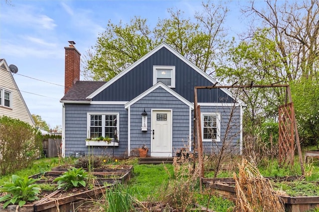 3215 E River Rd, Henrietta, NY 14623 - bungalow-style home featuring a vegetable garden and a chimney