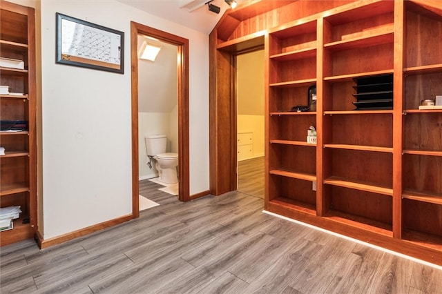 3215 E River Rd, Henrietta, NY 14623 - unfurnished bedroom with wood finished floors, baseboards, and connected bathroom