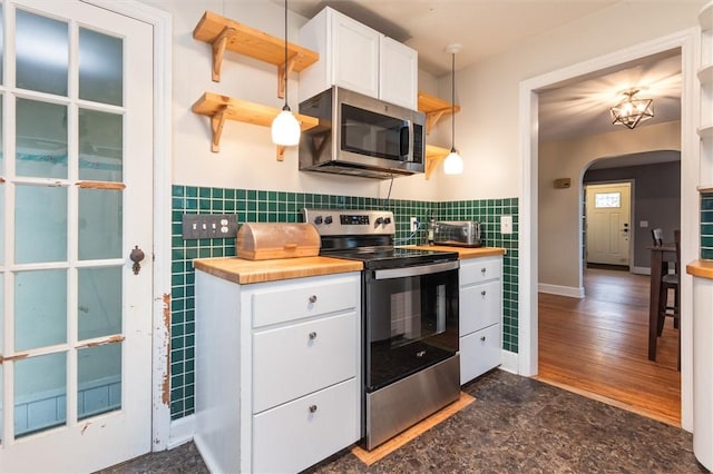 3215 E River Rd, Henrietta, NY 14623 - kitchen with appliances with stainless steel finishes, butcher block countertops, arched walkways, and white cabinets