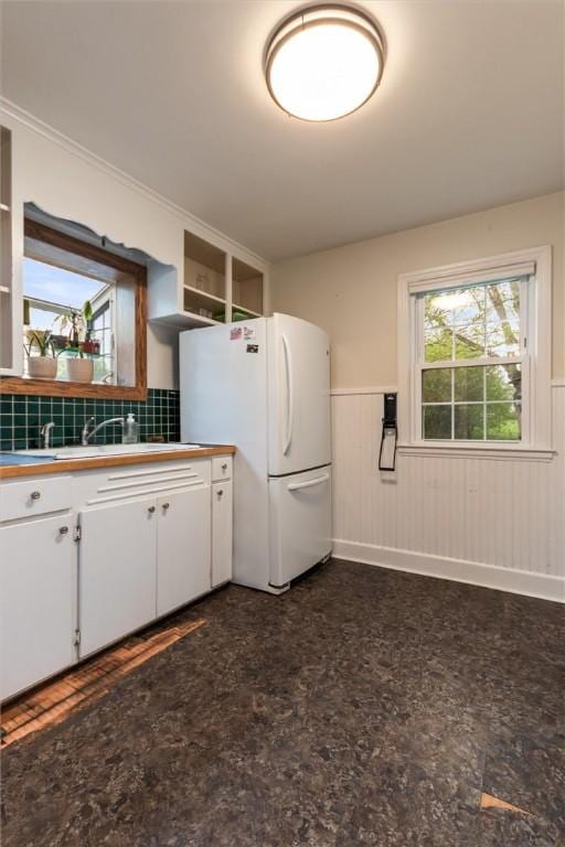 3215 E River Rd, Henrietta, NY 14623 - kitchen with freestanding refrigerator, wainscoting, white cabinets, open shelves, and a sink