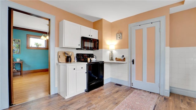 17 Varden St, Rochester, NY 14609 - kitchen with black appliances, a chandelier, white cabinets, light countertops, and light wood finished floors