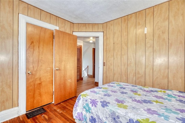 135 Cameron St, Rochester, NY 14606 - bedroom featuring wood finished floors, a textured ceiling, and wooden walls