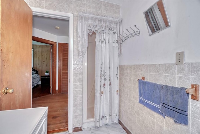 135 Cameron St, Rochester, NY 14606 - ensuite bathroom featuring tile walls, curtained shower, and wainscoting