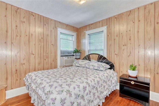 135 Cameron St, Rochester, NY 14606 - bedroom with wooden walls, wood finished floors, and cooling unit