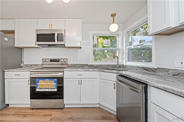 124 Aurora St, Rochester, NY 14621 - kitchen featuring stainless steel appliances, a sink, white cabinets, light stone countertops, and light wood finished floors